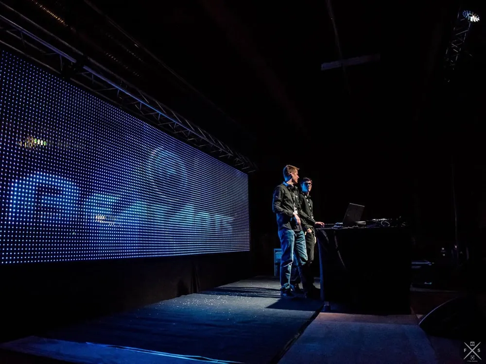 Zwei DJs am Pult neben einer großen LED-Wand mit BeatArts-Logo
